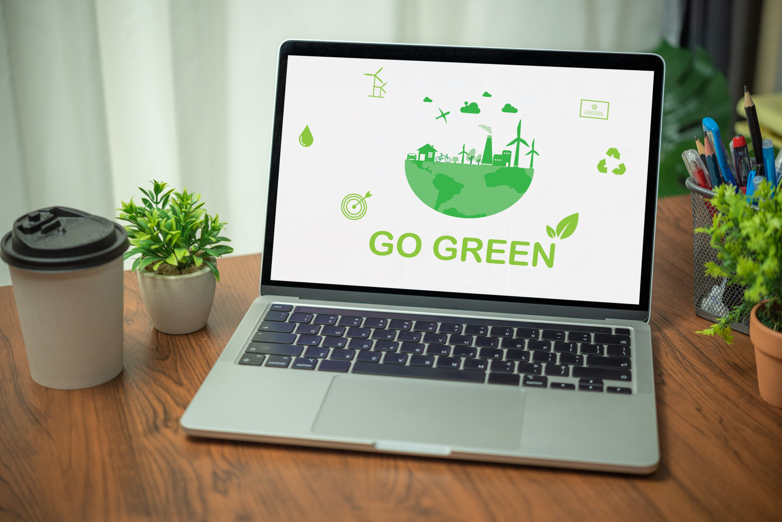 Stockphoto of a laptop that says Go Green and shows green symbols that relate to the environment