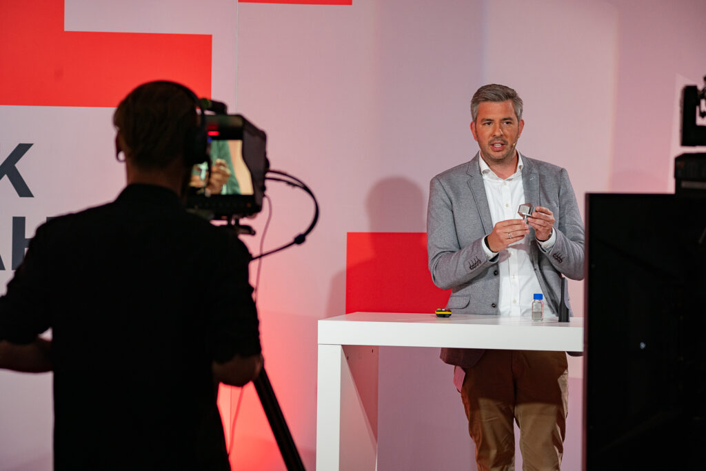 Additive Marking CEO Ulrich Jahnke presenting a part in front of a camera